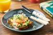 © 365mm/Stocksy - Close-up of toast with fish and avocado with greens on plate.