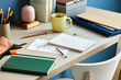 © 365mm/Stocksy - Student's desk with notes in notebooks and cup of drink in dayli