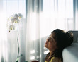 © ChaoShu Li/Stocksy - Cute Asian girl grimacing after getting up in bed in bed. shot by 120 films