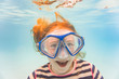 © blurMEDIA/Stocksy - Girl on family vacation has fun laughing in diving mask underwater in pool