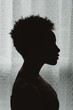 © Chelsea Victoria/Stocksy - A young African American woman in silhouette