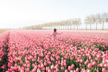 Happy Young Woman In A Tulip Field