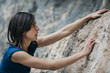 © Alberto Bogo/Stocksy - Woman hanging on rock