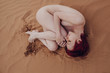 © Liliya Rodnikova/Stocksy - Naked young woman lying on sand
