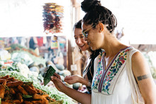 Woman Travelers Browsing A Fresh Fruit Market On Vacation