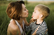 © Cavan Images - Mother kiss her little son outdoor