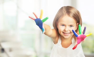 Wall Mural - Little girl showing painted hands on  background