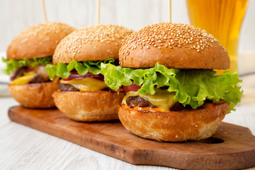 Homemade cheeseburgers and glass of cold beer, side view. Close-up.