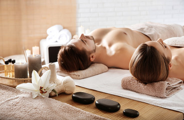 Poster - Young couple with spa essentials in wellness center