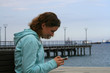 © Olga - Girl using smartphone at the seaside