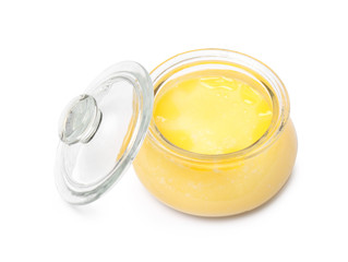 Glass jar with clarified butter on white background