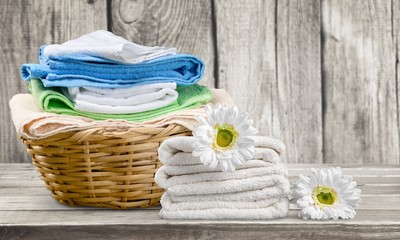 Laundry Basket with colorful towels on background