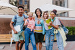 © Look! - Happy blonde girl wears jeans with holes posing outdoor near smiling friends. Outdoor portrait of pleased students holding laptop and backpacks in morning.