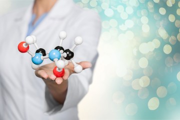 Wall Mural - Close up of Molecular structure model in hand on background