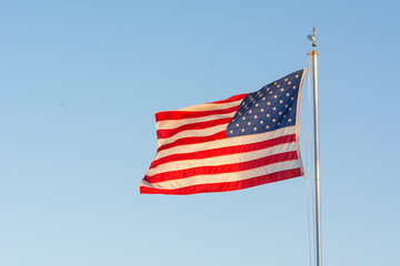 American National Flag Flitting in the Wind on Blue Sky BAckground