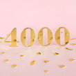 The number 4000 in golden numbers on a pink background and golden confetti. Space for text...