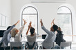© Look! - Portrait from back of young people sitting in front of windows in light office. Excited boys and girls which working together celebrating great deal in office.
