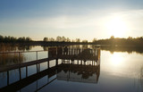 Fototapeta Pomosty - Old wooden arbor jetty on the lake at sunset.