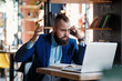 © Ilnur - Serious bearded businessman conducts telephone conversations on a mobile phone at the computer. Unhappy man scolds on the phone. Emitations of rage in the office at the manager
