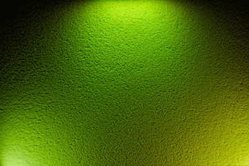 On a textural background, two sources of green light and one yellow light