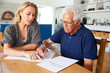 © Monkey Business - Woman Helping Senior Man To Complete Last Will And Testament At Home
