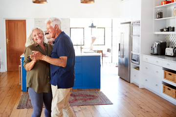 Wall Mural - Senior Couple At Home Dancing In Kitchen Together