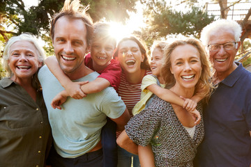 outdoor portrait of multi-generation family walking in countryside against flaring sun