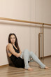 © MK studio - Beautiful girl dancer. tired girl dancer. girl ballerina or dancer is resting near the ballet barre in a dance studio after training.