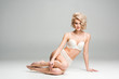 © LIGHTFIELD STUDIOS - beautiful sexy young woman in lingerie sitting, looking at camera and posing on grey