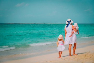 family on beach vacation-mother with two kids at sea