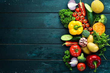 Fresh vegetables on a black background. Avocados, tomatoes, potatoes, paprika, citrus. Top view. Free space for your text.