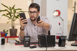 businessman, at the office, with expression gesture when seeing the smartphone