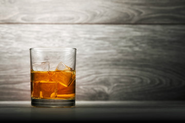 Wall Mural - Whiskey glass and ice on wooden bar counter background