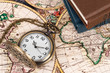 © wirojsid - Vintage pocket watch clock on ancient map background with books