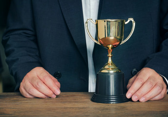 Wall Mural - trophy on the table with background businessman
