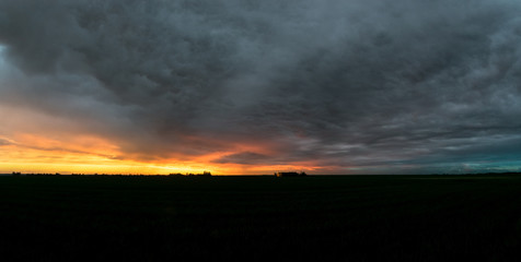 Wall Mural - dramatic sky over the dutch landscape after sunset. beautiful colors and textures in the sky. a dist