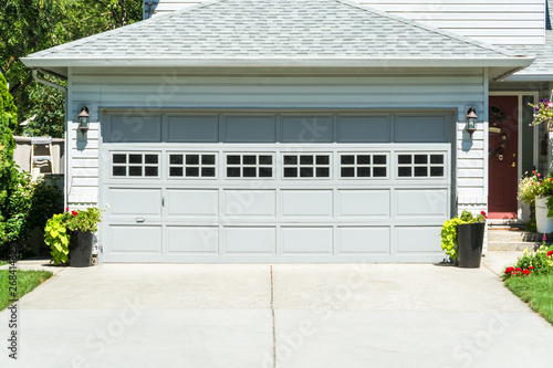 Fotografía Wide garage door of residential house and concrete driveway in front