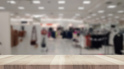 Empty wood table and blurred clothing store, product display montage