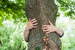 © pixarno - closeup of woman hugging a tree in a forest