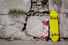 Two Colorful Skateboard Leaning On Cracked Wall