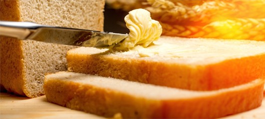 Sticker - Slices of bread with butter on wheat background