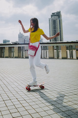 Wall Mural - Happy hipster girl enjoying skating on penny board