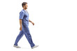 Young male doctor in a blue uniform walking