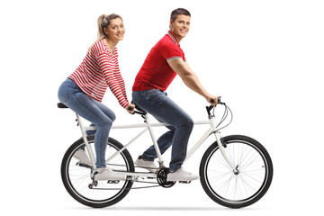 Wall Mural - Young man and woman on a tandem bicycle looking at the camera
