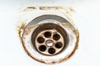 © ReaLiia - Dirty sink drain mesh, hole with limescale or lime scale and rust on it close up, dirty rusty bathroom washbowl