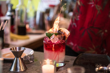 Bartender making Fresh tropical alcohol cocktails with fire on the bar counter