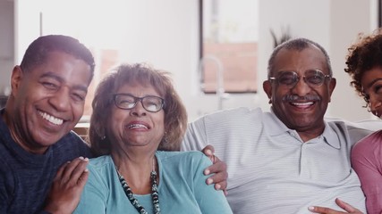 Wall Mural - Happy middle aged black couple and parents relax sitting together at home, close up