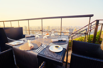 Sticker - Table setting on roof top restaurant with megapolis view, Bangkok Thailand.