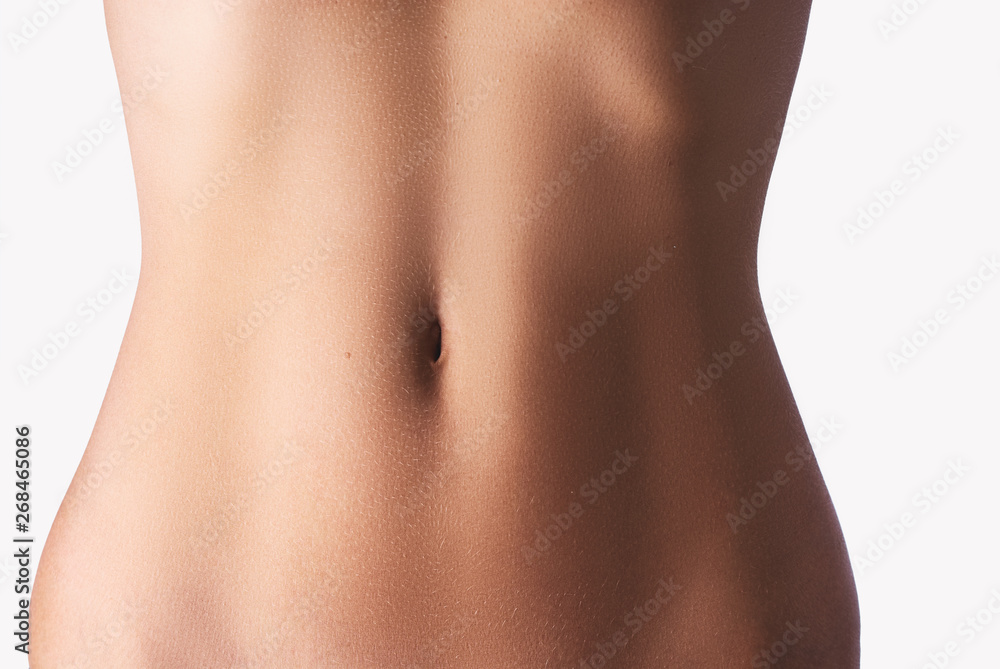 Close up of slim young woman belly isolated on white. - obrazy, fototapety, plakaty 