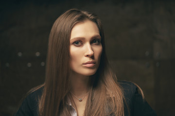 Wall Mural - Close up studio Portrait of Beautiful young caucasian woman with long hair against dark background